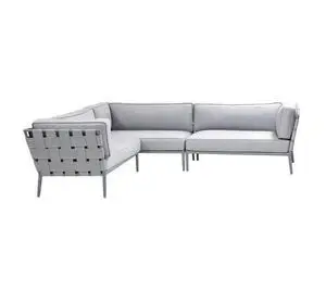 Lysegrå sektionssofa med flettet mønster på ryg og sider, lige ben og moderne design.